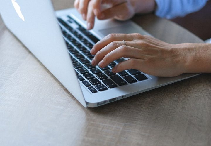 crop woman typing on portable netbook while sitting at home